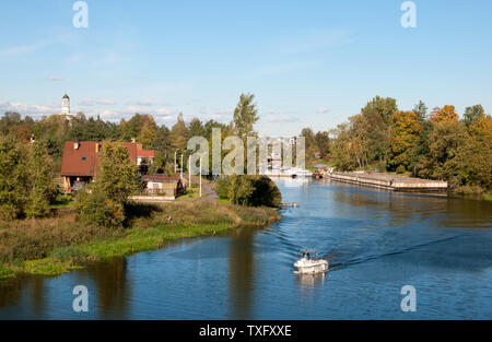 UST-IZHORA, St.-Petersburg, Russland - 29. SEPTEMBER 2018: Weiße Boot auf dem izhora River. Auf der linken Seite ist Alexander Newski Kirche Stockfoto