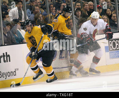 Boston Bruins center Patrice Bergeron kommt Weg mit dem Puck als Ottawa Senators rechten Flügel Chris Neil Schecks Boston Bruins defenseman Hal Gill im TD Banknorth Garden in Boston, am 5. Januar 2006. Die Bruins gewann das Spiel 4-2. (UPI Foto/Katie McMahon) Stockfoto