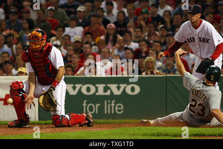 Boston Red Sox catcher Jason Varitek erhält die werfen zu spät wie Oakland Athletics left fielder Bobby Kietly kreuzt die Platte im elften Inning, setzen die A's vor Boston 5-3 am Fenway Park in Boston am 13. Juli 2006. (UPI Foto/Katie McMahon) Stockfoto