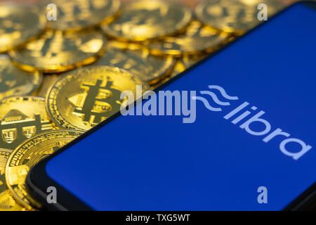 Gold Bitcoin Münze mit der Facebook Waage Crypto Münze logo Bildschirm Hintergrund Stockfoto