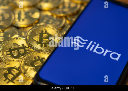 Gold Bitcoin Münze mit der Facebook Waage Crypto Münze logo Bildschirm Hintergrund Stockfoto