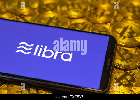 Gold Bitcoin Münze mit der Facebook Waage Crypto Münze logo Bildschirm Hintergrund Stockfoto