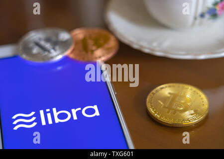 Gold Bitcoin Münze mit der Facebook Waage Crypto Münze logo Bildschirm Hintergrund Stockfoto