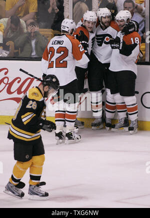 Philadelphia Flyers Spieler von Links, linker Flügel Ville Leino (22), Verteidiger Matt Carle (25) und Mike Richards (18) gratulieren Mannschaftskamerad linken Flügel Simon Gagne (12) Auf seiner dritten Periode Ziel wie Boston Bruins rechten Flügel Mark Recchi (28) Skate zurück zu der Bank in Spiel 7 der NHL Eastern Conference Halbfinale am TD Garden in Boston, Massachusetts am 14. Mai 2010. Die Flieger besiegten die Bruins 4-3. UPI/Matthew Healey Stockfoto