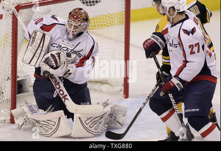 Washington Capitals goalie Braden Holtby (70) Hält einen Schuß aus der Sicht von den Boston Bruins als Teamkollege defenseman Karl Alzner (27) und die Boston Bruins, Brad Marchand Masse das Netz in der zweiten Periode von Spiel eins der NHL Eastern Conference Viertelfinale bei TD Garden in Boston, Massachusetts am 12. April 2012. UPI/Matthew Healey Stockfoto