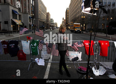 Ein fernsehreporter überprüft Ihr Telefon vor Berichterstattung vor einen provisorischen Denkmal in Reaktion auf die Montag Boston Marathon Bombenanschlag auf der Boylston Street in Boston, Massachusetts am 17. April 2013. Am Montag, zwei Bomben detoniert in der Nähe der Ziellinie der Boston Marathon töten 3 und über 140 wurden verletzt. UPI/Matthew Healey Stockfoto