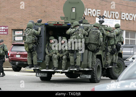 SWAT-Team Mitglieder sind Schule Straße in Watertown, Massachusetts in der Rückseite eines gepanzerten Fahrzeug während einer Grossfahndung für einen der beiden Boston Marathon Bombardierung Verdächtigen am 19. April 2013. Montag Boston Marathon Bombardierung links drei Tote und über 170 Verletzte. UPI/Matthew Healey Stockfoto