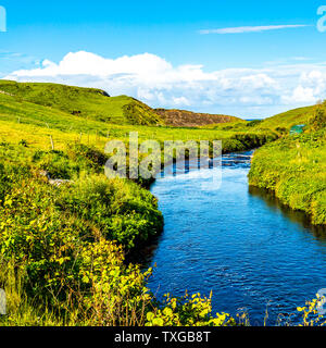 Schöne grüne Wiese mit einem Bach in der Nähe der Ortschaft Doolin, wilden Atlantik, wunderbar sonniger Frühling in der Grafschaft Clare in Irland Stockfoto