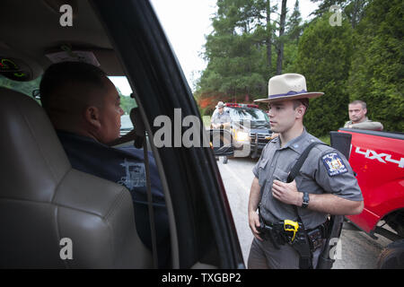 Tom Chubb des Akawesasne Mohikaner Chats mit einem New York State Trooper Polizei bei einer Fahrzeugkontrolle, während er für entgangenen gefangenen David Schweiß und Richard Matt in der Nähe von Malone, New York am 25. Juni 2015 auf der Suche war. Die beiden Freunde haben mehrere Abende auf der Suche nach den Gefangenen in die Hoffnungen der Erhebung der Belohnung Geld ausgegeben. Foto von Matthew Healey/UPI Stockfoto