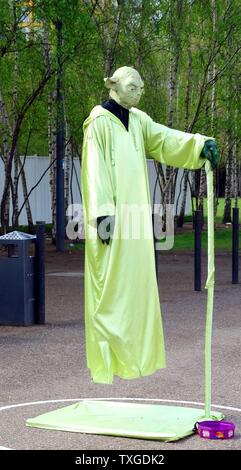 Straßenkünstler gekleidet wie Yoda. Der Künstler schafft die Illusion, die er schwebt. London, Vereinigtes Königreich. Datierte 1015 Stockfoto