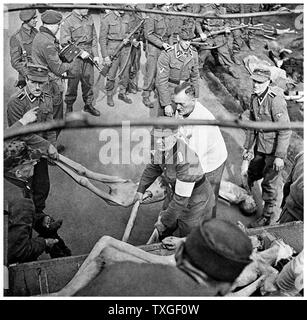 SS bewacht Last Opfer des KZ Bergen-Belsen, in einem Lastwagen für die Beerdigung, 1945 Stockfoto