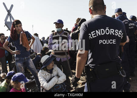 Flüchtlinge und Migranten warten auf Bussen in der Nähe von der Grenze mit Serbien in Roszke, Ungarn am 8. September 2015. Sie werden in eine Registrierung Camp, bevor sie ihre Reise in Richtung Deutschland übertragen werden. Foto von Achilleas Zavallis/UPI Stockfoto