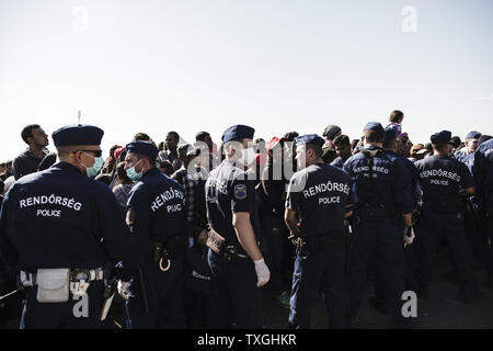 Flüchtlinge und Migranten warten auf Bussen in der Nähe von der Grenze mit Serbien in Roszke, Ungarn am 8. September 2015. Sie werden in eine Registrierung Camp, bevor sie ihre Reise in Richtung Deutschland übertragen werden. Foto von Achilleas Zavallis/UPI Stockfoto