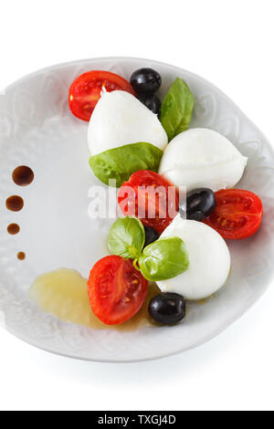 Mozzarella, Tomaten und Basilikum auf der Platte. Auf blau rustikal Tisch. Stockfoto