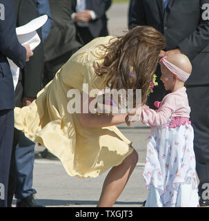 Auf der letzten Etappe ihrer Royal tour, Prinz William Uhren seiner Frau Kate hug Krebs Patienten und Flower Girl Diamond Marshall während der Herzog und die Herzogin von Cambridge Ankunft durch militärische Hubschrauber für ihre Weißen hatting Zeremonie in Calgary, Alberta, 7. Juli 2011. UPI/Heinz Ruckemann Stockfoto