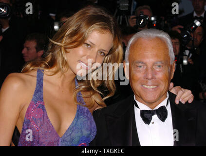 Designer Giorgio Armani und seine Datum posieren für die Fotografen auf dem roten Teppich vor der Galavorstellung der Abschlussfilm des Filmfestivals in Cannes e-schönen 'D' im Palais des Festivals vom 22. Mai 2004 in Cannes, Frankreich. (UPI Foto/Christine Kauen) Stockfoto