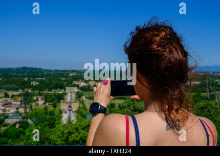 Brunette Mädchen, das Bilder mit dem Telefon in Valleggio sul Mincio, Italien Stockfoto