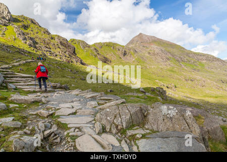 Ein Wanderer auf dem Weg zur Krippe Pyg Track Goch (Skyline) kurz nach Verlassen der Pen Y Pass Parkplatz, Snowdonia National Park, Gwynedd, Wales, Großbritannien Stockfoto