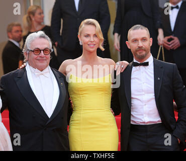 George Miller (L), Charlize Theron (C) und Tom Hardy kommen auf den Stufen des Palais des Festivals vor der Vorführung des Films "Mad Max: Fury Road" während der 68. Internationalen Filmfestspiele von Cannes in Cannes, Frankreich am 14. Mai 2015. Foto von David Silpa/UPI Stockfoto