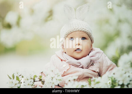 Ein kleines Mädchen, gekleidet wie ein Häschen in Blumen, Ostern Stockfoto