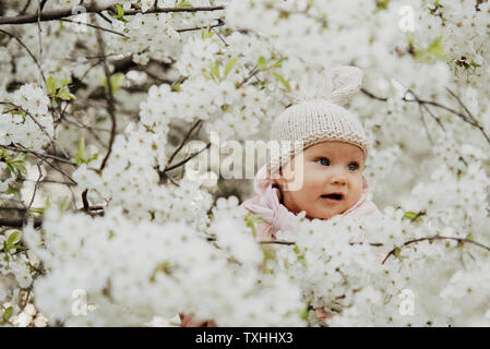 Ein kleines Mädchen, gekleidet wie ein Häschen in Blumen, Ostern Stockfoto