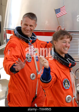 Mission Spezialisten Lisa Nowak und British-born Piers Sellers wave amerikanische Flaggen, als Sie den Betrieb und die Kasse Gebäude der NASA Astro-van Board auf dem Weg zum Space Shuttle Discovery zur Mission STS-121 in Cape Canaveral, Florida am 4. Juli 2006. (UPI Foto/Pat Benic) Stockfoto