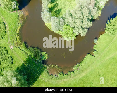 Foto von oben auf einer kurvenreichen Fluss von grünen Feldern und Bäumen umgeben Stockfoto