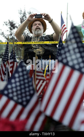 Veteran Michael A. Jarvis macht Fotografien aus seinem Rollstuhl auf einen provisorischen Denkmal an der US Navy Operational Support Center & Marinekorps-reserve Zentrum in Chattanooga, Tennessee am 20. Juli 2015. Die shootings an zwei verschiedenen Standorten links fünf US-Marines und der Schütze Mohammod Youssuf Abdulazeez tot. Foto von Billy Wochen/UPI Stockfoto