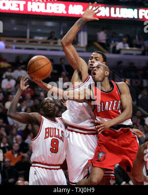 Portland Trail Blazers' Jarrett Jack, rechts, geht oben für eine Aufnahme, wie Tyson Chicago Bulls Chandler, Mitte, und Luol Deng, der Sudan, verteidigt im ersten Quartal ein NBA Basketball Spiel am 14. März 2006 in Chicago. (UPI Foto/Brian Kersey) Stockfoto