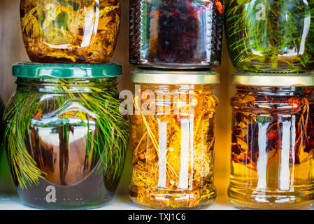 Gläser mit Honig und natürliche bunte Kräuter für Verkauf auf Regalen Stockfoto