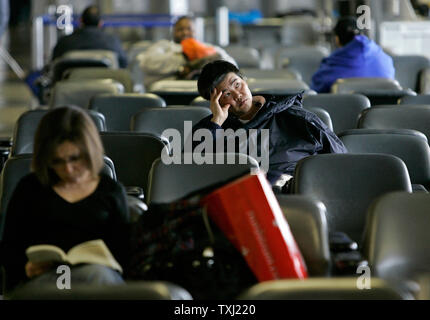 Hyun Su Lee (C) von Raleigh, North Carolina, wartet auf seinen Flug nach Hause bei der O'Hare International Airport in Chicago am 1. Dezember 2006. Lee's Flug wie am Freitag abgesagt und er nicht imstande war, einen anderen Flug zu buchen bis Samstag Morgen. Der erste Schneesturm des Winters hit Northern Illinois, Wisconsin und Michigan verursacht viele Verspätungen und Annullierungen an der Chicagoer Flughäfen. (UPI Foto/Brian Kersey) Stockfoto