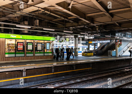 Shinagawa, Japan - 17. April 2019: Hauptbahnhof Plattform mit dem Shinkansen und salaryman Menschen, die darauf warten von Store Stockfoto