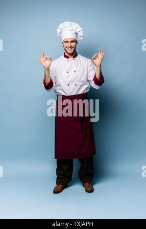 Positive Professionelle happy Mann Koch Übersicht lecker ok Zeichen isoliert auf Hellblau. Stockfoto