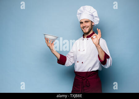 Positive Professionelle happy Mann Koch Übersicht lecker ok Zeichen isoliert auf Hellblau. Stockfoto