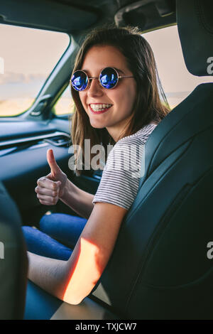 Mädchen Daumen hoch, im Auto Stockfoto