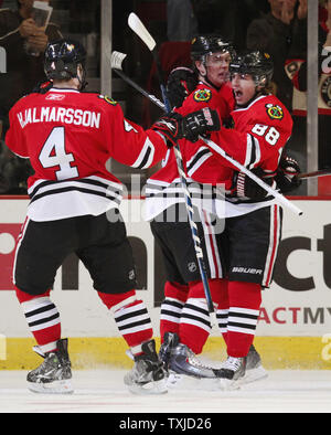 Chicago Blackhawks' Niklas Hjalmarsson (L), Jonathan Toews und Patrick Kane (R) feiern Toews' Ziel während der ersten Zeit gegen die Washington Capitals in der vereinigten Mitte in Chicago am 14. März 2010. UPI/Brian Kersey Stockfoto