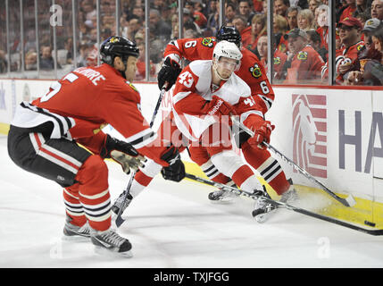 Detroit Red Wings center Darren Helm (C) und Chicago Blackhawks defenseman Jassen Cullimore (L) und defenseman Jordan Hendry gehen für den Puck während des zweiten Zeitraums in der vereinigten Mitte in Chicago am 17. Dezember 2010. UPI/Brian Kersey Stockfoto
