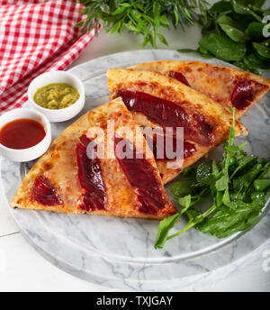 Geräucherten Rippchen Pizza mit Rucola und Parmesan auf Holz Tisch Hintergrund. Stockfoto