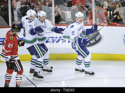 Vancouver Canucks' Daniel Sedin (R-L), Henrik Sedin und Alexander Edler feiern Daniel Sedin's Ziel als Chicago Blackhawks linken Flügel Viktor Stalberg Schweden skates entfernt während des zweiten Zeitraums der NHL Western Conference Viertelfinale in der vereinigten Mitte in Chicago am 17. April 2011. UPI/Brian Kersey Stockfoto