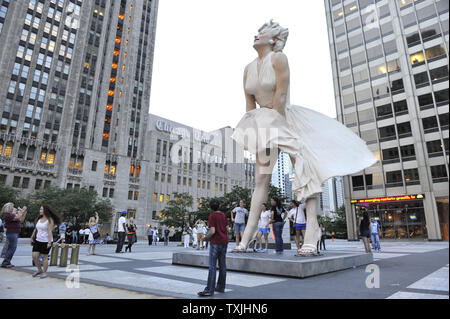 Menschen posieren für Fotos mit 'Forever Marilyn", einer Skulptur von Seward Johnson, am 15. Juli 2011 bei Pioneer Plaza in Chicago. Inspiriert von Marilyn MonroeÕs kultigen Pose aus dem Jahr 1955 Film ist sogar Jahr Itch", Edelstahl und Aluminium Skulptur steht 26 Meter hoch und wiegt 34.000 Pfund und wird auf dem Display durch die Frühjahr 2012. UPI/Brian Kersey Stockfoto