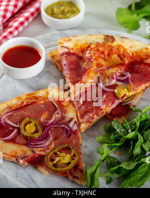 Geräucherten Rippchen Pizza mit Rucola und Parmesan auf Holz Tisch Hintergrund. Stockfoto