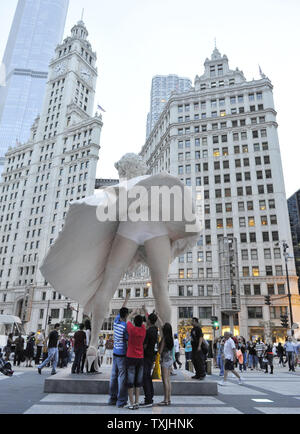 Menschen posieren für Fotos mit 'Forever Marilyn", einer Skulptur von Seward Johnson, am 15. Juli 2011 bei Pioneer Plaza in Chicago. Inspiriert von Marilyn MonroeÕs kultigen Pose aus dem Jahr 1955 Film ist sogar Jahr Itch", Edelstahl und Aluminium Skulptur steht 26 Meter hoch und wiegt 34.000 Pfund und wird auf dem Display durch die Frühjahr 2012. UPI/Brian Kersey Stockfoto