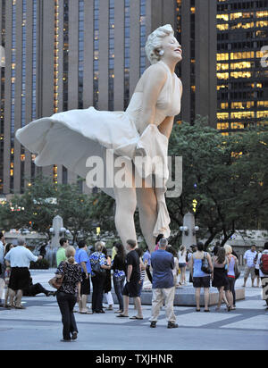 Menschen posieren für Fotos mit 'Forever Marilyn", einer Skulptur von Seward Johnson, am 15. Juli 2011 bei Pioneer Plaza in Chicago. Inspiriert von Marilyn MonroeÕs kultigen Pose aus dem Jahr 1955 Film ist sogar Jahr Itch", Edelstahl und Aluminium Skulptur steht 26 Meter hoch und wiegt 34.000 Pfund und wird auf dem Display durch die Frühjahr 2012. UPI/Brian Kersey Stockfoto