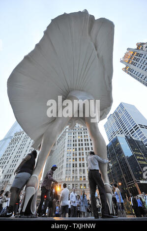 Menschen posieren für Fotos mit 'Forever Marilyn", einer Skulptur von Seward Johnson, am 15. Juli 2011 bei Pioneer Plaza in Chicago. Inspiriert von Marilyn MonroeÕs kultigen Pose aus dem Jahr 1955 Film ist sogar Jahr Itch", Edelstahl und Aluminium Skulptur steht 26 Meter hoch und wiegt 34.000 Pfund und wird auf dem Display durch die Frühjahr 2012. UPI/Brian Kersey Stockfoto