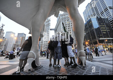 Menschen posieren für Fotos mit 'Forever Marilyn", einer Skulptur von Seward Johnson, am 15. Juli 2011 bei Pioneer Plaza in Chicago. Inspiriert von Marilyn MonroeÕs kultigen Pose aus dem Jahr 1955 Film ist sogar Jahr Itch", Edelstahl und Aluminium Skulptur steht 26 Meter hoch und wiegt 34.000 Pfund und wird auf dem Display durch die Frühjahr 2012. UPI/Brian Kersey Stockfoto