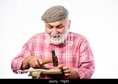 Perfektes Design. retro Mann Reparatur Schuhe mit einem Hammer. Schuster Verarbeitung. Schuster arbeiten mit Leder Textil- und Hammer an Workshop. Schuster bei der Arbeit. reife Schuster in der Werkstatt Schuhe machen. Stockfoto