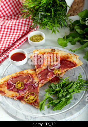 Geräucherten Rippchen Pizza mit Rucola und Parmesan auf Holz Tisch Hintergrund. Stockfoto