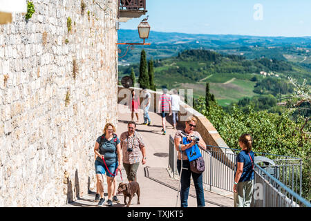 San Gimignano, Italien - 27 August, 2018: die Menschen zu Fuß erkunden kleine historische mittelalterliche Stadt Dorf in der Toskana mit Blick auf die sanften Hügel Stockfoto