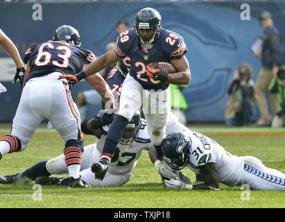 Chicago Bears zurück läuft, Michael Busch (C) läuft durch Seattle Seahawks defensive Brandon Mebane (L) und starke Sicherheit kam Bundeskanzler auf diese Weise zu einem 12-Yard-Gewinn im zweiten Quartal Gerät an Soldier Field am 2. Dezember in Chicago 2012. Die Seahawks gewann 23-17 in den überstunden. UPI/Brian Kersey Stockfoto