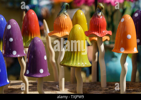 Ausstellung von orangefarbenen, roten, violetten und gelben Keramikpilzen und -Hockern auf einer Blumenschau in Harrogate, North Yorkshire, England, Großbritannien. Stockfoto